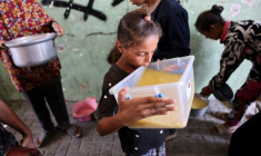 Une fillette palestinienne prend une gorgée d'une soupe aux lentilles reçue à un point de distribution de nourriture dans la ville de Gaza, le 25 juillet 2025 ( AFP / Omar AL-QATTAA )
