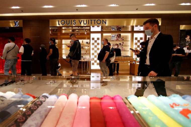 Des clients font la queue devant un magasin Louis Vuitton à Paris