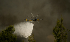 Un hélicoptère de lutte contre les incendies largue de l'eau sur un feu de forêt dans la région de Porto Germeno, à environ 70 kilomètres au nord-ouest d'Athènes, dans la région de Béotie, le 2 août 2026 ( AFP / Angelos TZORTZINIS )
