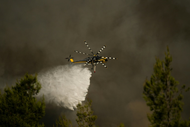 Un hélicoptère de lutte contre les incendies largue de l'eau sur un feu de forêt dans la région de Porto Germeno, à environ 70 kilomètres au nord-ouest d'Athènes, dans la région de Béotie, le 2 août 2026 ( AFP / Angelos TZORTZINIS )