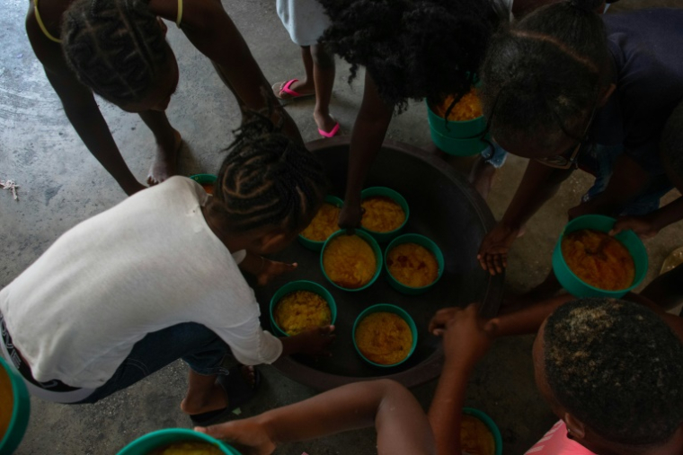 Des enfants font la queue pour de la nourriture dans une école transformée en refuge pour les personnes déplacées par les violences liées aux gangs, le 22 avril 2024 à Port-au-Prince, en Haïti ( AFP / Clarens SIFFROY )