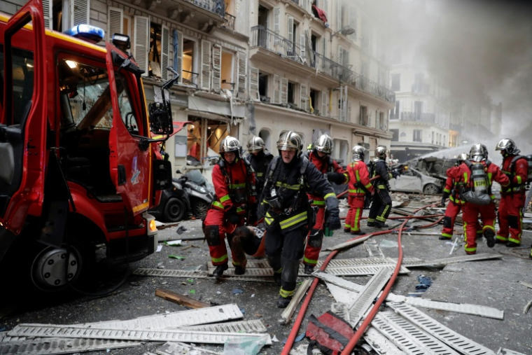 Des pompiers au secours de victimes après l'explosion au gaz de la rue de Trévise, le 12 janvier 2019 à Paris ( AFP / Thomas SAMSON )