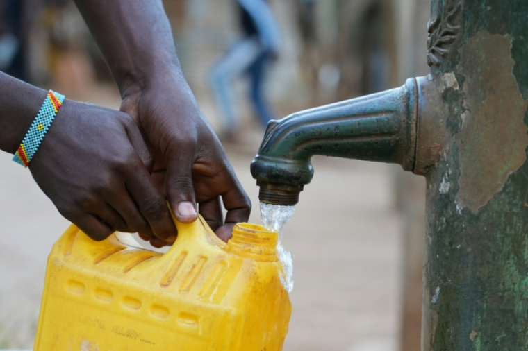 Une personne remplit un jerrican à une fontaine à eau payante à  Tsoundzou 2, un bidonville de Mamoudzou, le 31 octobre 202 à Mayotte ( AFP / Marine GACHET )