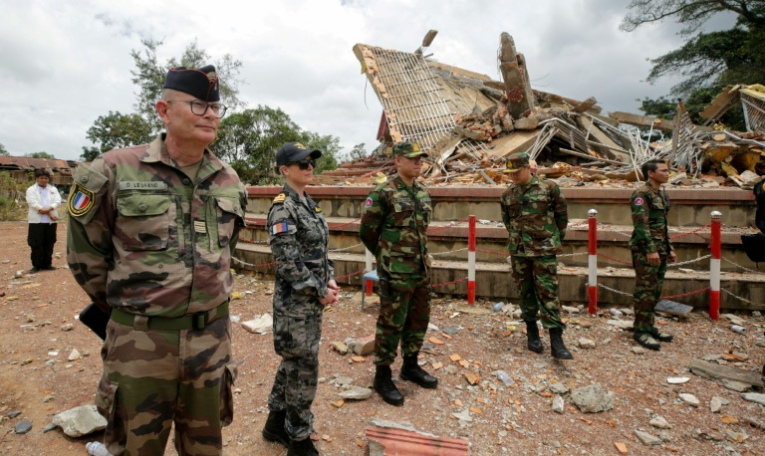 Des attachés militaires et des diplomates de 13 pays, dont la France (à gauche) observent la mise en œuvre de l'accord de cessez-le-feu entre le Cambodge et la Thaïlande à côté d'un bâtiment détruit près du poste-frontière d'An Ses dans la province cambodgienne de Preah Vihear, le 30 juillet 2025 ( AFP / Chor Sokunthea )