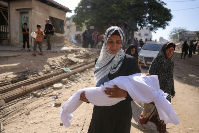 Une Palestinienne porte un enfant mort dans ses bras, devant l'hôpital Shifa à Gaza-ville,  pour l'emmener à des funérailles, le 29 août 2025 ( AFP / BASHAR TALEB )