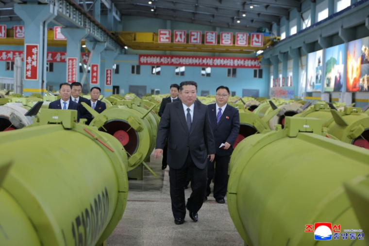 Cette photo non datée, publiée par l'agence de presse officielle nord-coréenne KCNA le 26 décembre 2025, montre le dirigeant nord-coréen Kim Jong Un (c) en visite dans une usine de production de missiles et d'obus ( KCNA VIA KNS / STR )