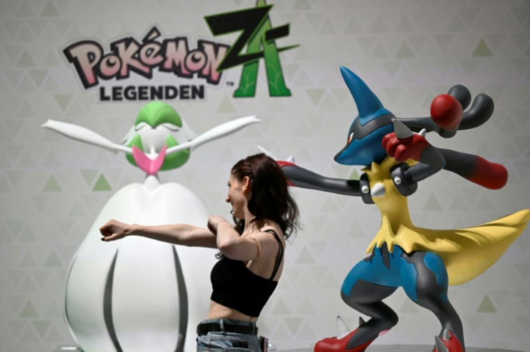 Une visiteuse du salon des jeux vidéo Gamescom  devant des figurines du jeu "Légendes Pokémon: Z-A" de Nintendo le 19 août 2025 à Cologne, en Allemagne ( AFP / Ina FASSBENDER )