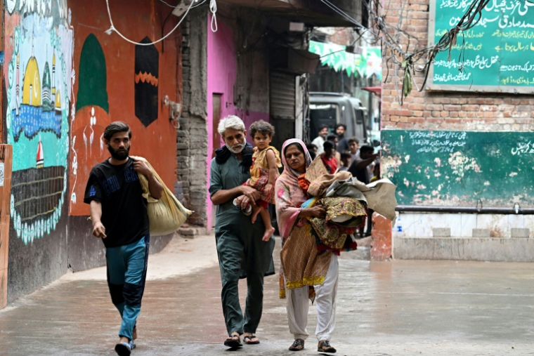 Des habitants dont les maisons ont été submergées par les eaux en crue du fleuve Ravi arrivent dans une école publique servant de refuge temporaire à Shahdara, le 29 août 2025 au Pakistan ( AFP / Aamir QURESHI )