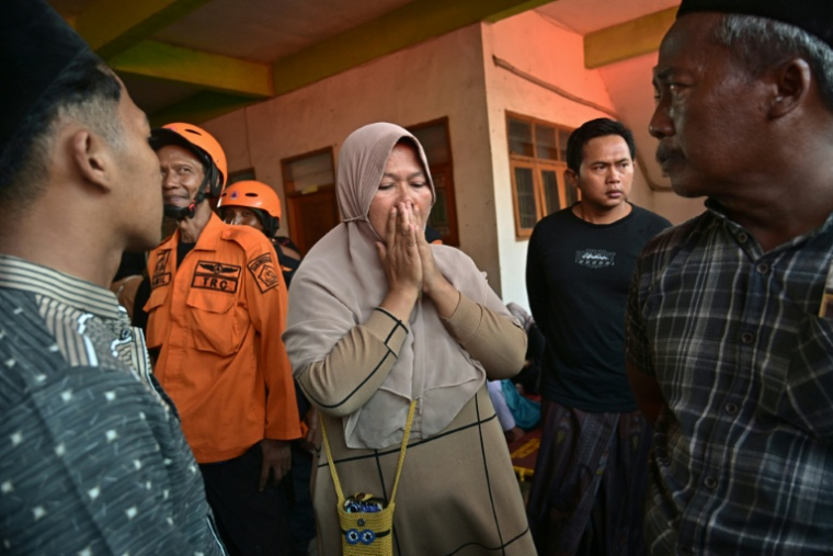Deux jours après l'effondrement d'une école islamique à Sidoarjo en Indonésie, des proches d'élèves portés disparus se réunissent pendant que les secouristes tentent de retrouver des survivants le 1er octobre 2025. ( AFP / Juni KRISWANTO )