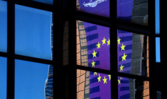 Une bannière représentant un drapeau de l'Union européenne se reflète dans une fenêtre à l'extérieur du siège du Conseil de l'Union européenne à Bruxelles