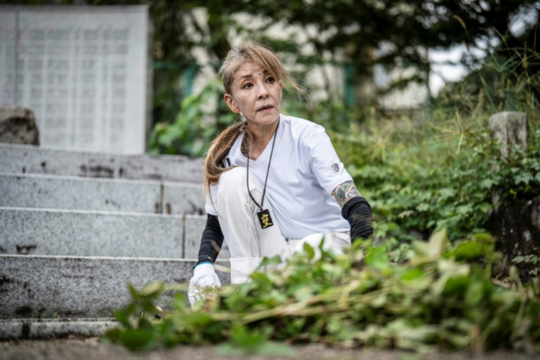 Mako Nishimura, yakuza à la retraite, ramasse des feuilles mortes lors d'une activité de nettoyage au sanctuaire Gokoku à Gifu, le 28 septembre 2025 au Japon ( AFP / Yuichi YAMAZAKI )