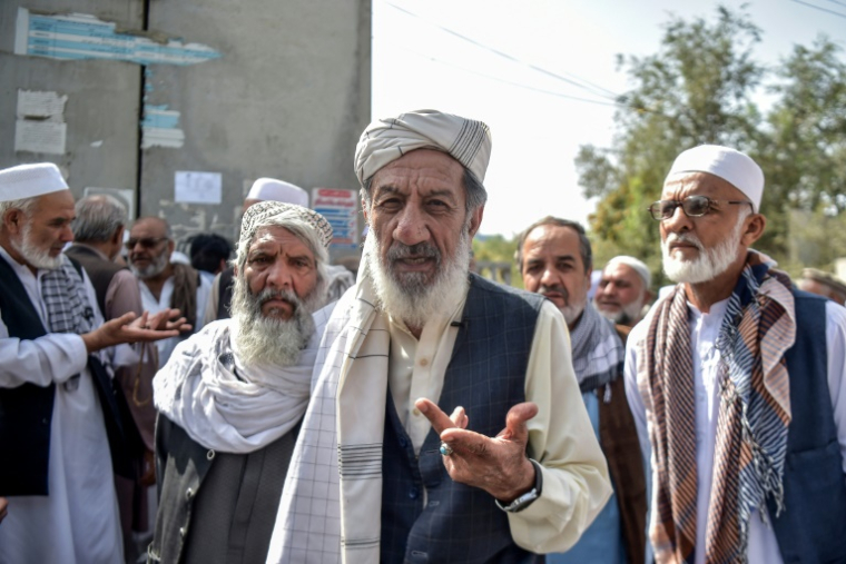 Le retraité Abdul Sabir (c) lors d'une interview avec l'AFP devant un bâtiment gouvernemental à Kabou, le 25 août 2025 en Afghanistan ( AFP / Bais Yusufi )