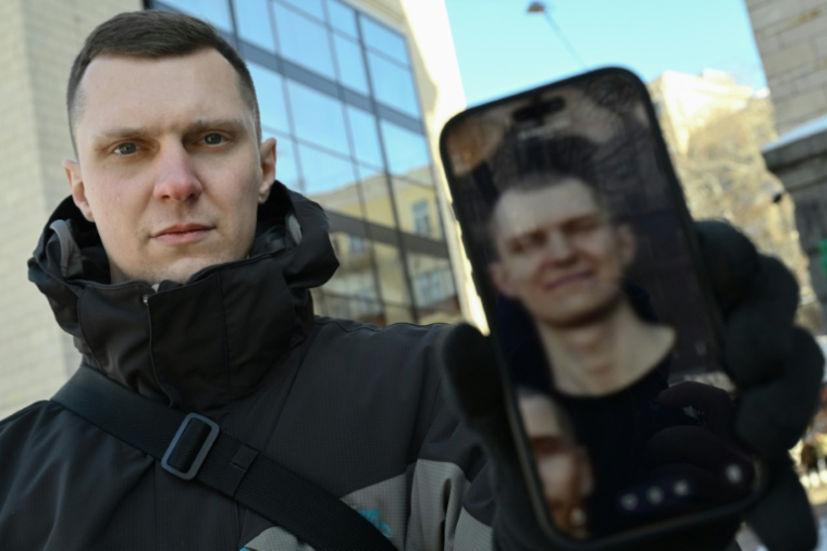 L'ex-soldat ukrainien Iaroslav Roumiantsev, montre une photo de lui durant sa captivité dans une prison russe. Kiev, 2 février 2026 ( AFP / Genya SAVILOV )