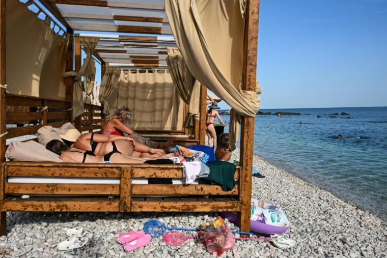 Des touristes bronzent sur une plage à Simeïz, en Crimée annexée, le 21 juillet 2026 ( AFP / Igor IVANKO )