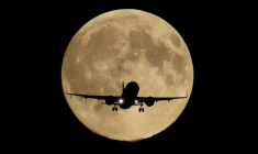 Un avion de ligne survole Londres et passe devant la super lune Harvest Moon