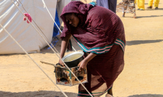 Une femme qui a fui El-Facher, ville du Darfour (ouest) prise par les paramilitaires, prépare à manger dans un camp pour déplacés soudanais  à al-Dabbah, le 13 novembre 2025 ( AFP / Ebrahim Hamid )