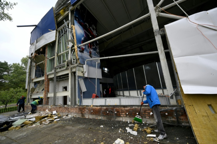 Un employé enlève des débris devant la patinoire Chalet Ice Arena de Kiev endommagée par des bombardements russes, le 19 octobre 2026  ( AFP / Sergei SUPINSKY )