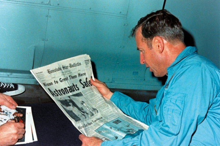 Jim Lovell en train de lire le journal évoquant le sauvetage périlleux d'Apollo 13 le 17 avril 1970, à bord de l'USS Iwo ( NASA / Handout )