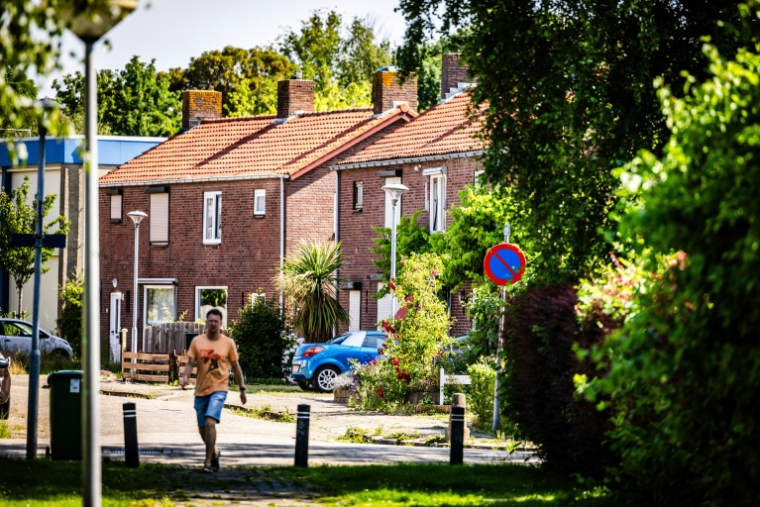 Un habitant marche dans une rue d’un quartier résidentiel du village de Moerdijk, dans le sud des Pays-Bas, le 22 juin 2026. Moerdijk est un village portuaire de 1.150 habitants placé entre les ports de Rotterdam et d'Anvers, en Belgique. C'est ici que le gouvernement néerlandais a choisi d'implanter une zone destinée à recevoir l'électricité produite par les parcs éoliens en mer et à rendre plus durable l'industrie portuaire du pays ( ANP / Jeffrey Groeneweg )