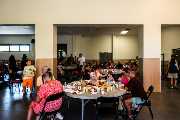 Des touristes et des personnes évacués prennent un petit déjeuner dans une salle à Canet-en-Roussillon (sud) le 3 juillet 2026. ( AFP / Jc Milhet )