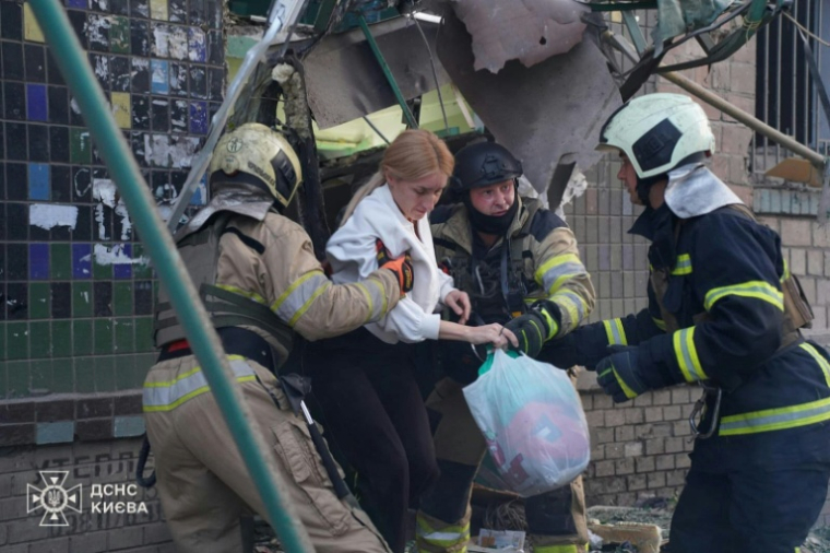Cette photo diffusée et publiée par le Service d'urgence ukrainien le 23 juin 2025 montre des secouristes évacuant des habitants d'un bâtiment endommagé après des frappes nocturnes de drones et de missiles russes à Kiev ( Ukrainian State Emergency Service / Handout )
