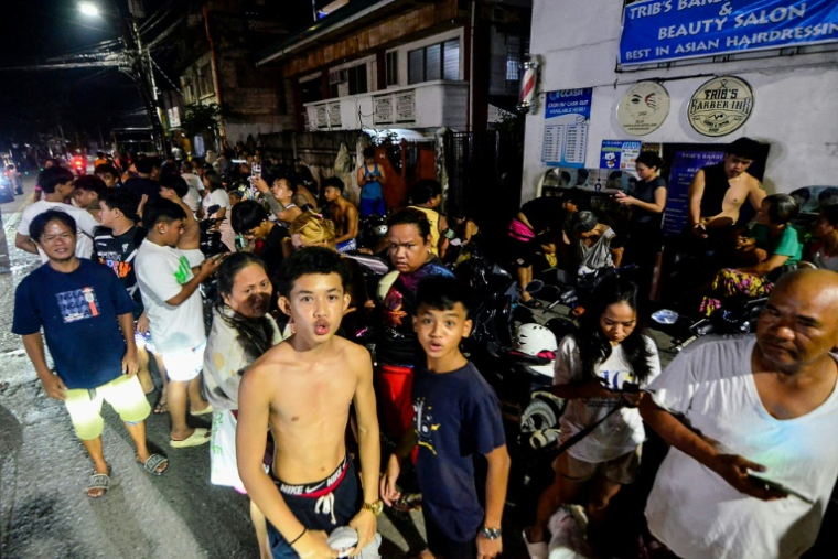 Des habitants se rassemblent dans une rue devant leurs maisons après les secousses du tremblement de terre à Mandaue à Cebu, dans le centre des Philippines, le 30 septembre 2025. ( AFP / Alan TANGCAWAN )