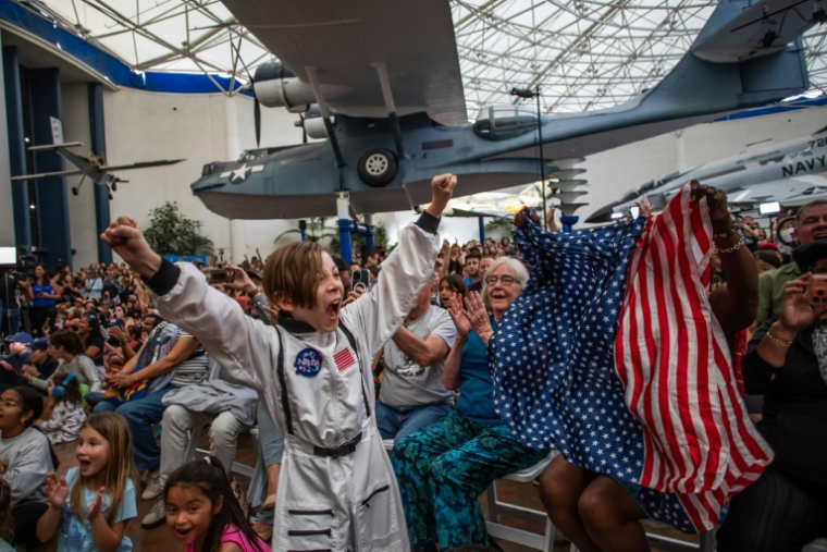 Un garçon célèbre le retour réussi sur la Terre des astronautes de la mission Artémis II au musée de l'air et de l'espace de San Diego le 10 avril 2026 ( AFP / Apu GOMES )