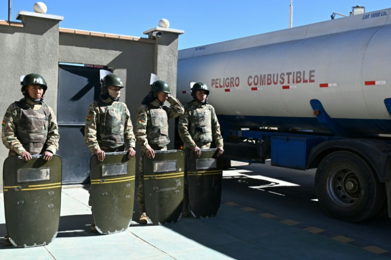 Des soldats boliviens sécurisent l'entrée de camions-citernes dans le complexe pétrolier public de Senkata, à El Alto, le 21 juin 2026, au lendemain de la proclamation de l'état d'exception par le président Rodrigo Paz ( AFP / AIZAR RALDES )