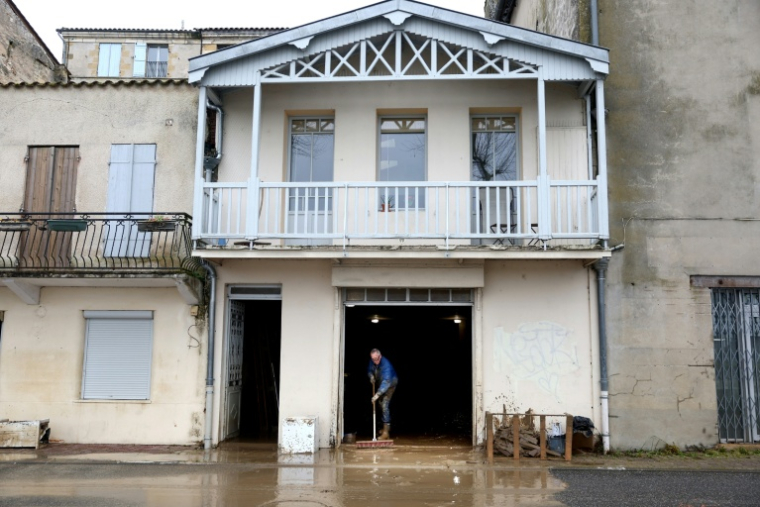 Un habitant nettoie la boue amassé sur le sol d'une maison lors des inondations à La Réole, près de Bordeaux, le 23 février 2026 ( AFP / ROMAIN PERROCHEAU )