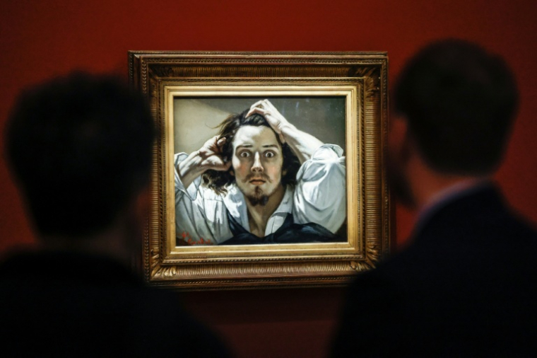 Des visiteurs devant le tableau "Le Désespéré", célèbre autoportrait du peintre français Gustave Courbet, exposé au musée d'Orsay à Paris, le 13 octobre 2025 ( AFP / Ian LANGSDON )