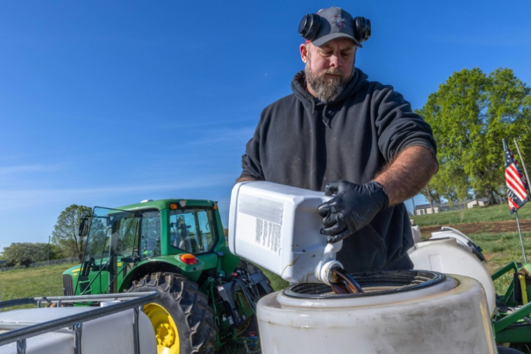 L'agriculteur Russell Hedrick prépare un mélange de minéraux, de produits biologiques et d'engrais pour le pulvériser sur ses champs lors des semis à Hickory, en Caroline du Nord, le 10 avril 2026 ( AFP / Grant Baldwin )
