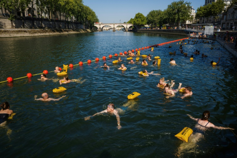 Des baigneurs dans la Seine au bras Marie à Paris le 12 août 2025 ( AFP / Dimitar DILKOFF )