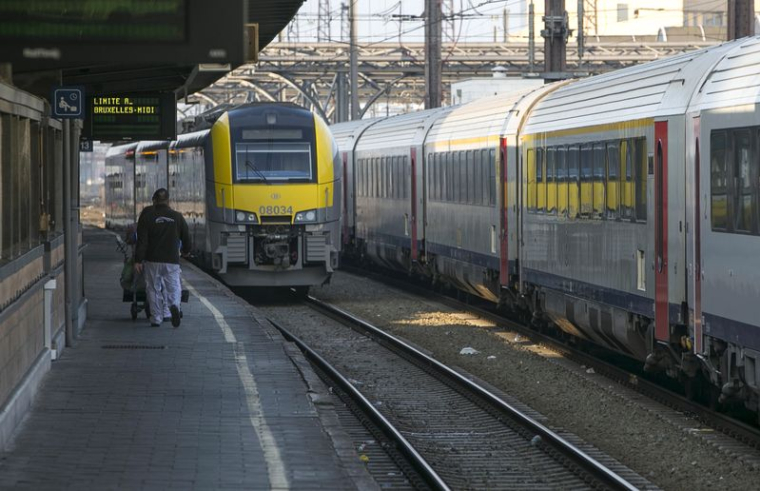 Un travailleur marche sur le quai d'une gare