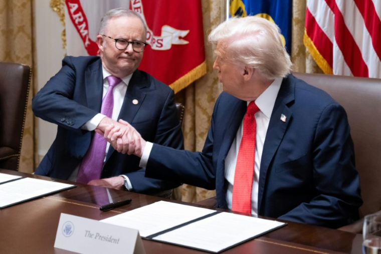 Le président américain Donald Trump (d) et le Premier ministre australien Anthony Albanese se serrent la main après la signature d'un accord sur les minéraux critiques à la Maison Blanche, le 20 octobre 2025 à Washington ( AFP / SAUL LOEB )