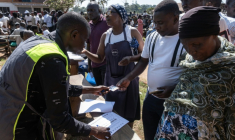 Des responsables de la Commission électorale vérifient les noms des électeurs sur le registre électoral avant leur vote à Kampala lors des élections générales, le 15 janvier 2026 en Ouganda ( AFP / Badru Katumba )