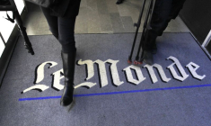 Un journaliste marche sur le logo du quotidien français Le Monde dans leurs bureaux à Paris