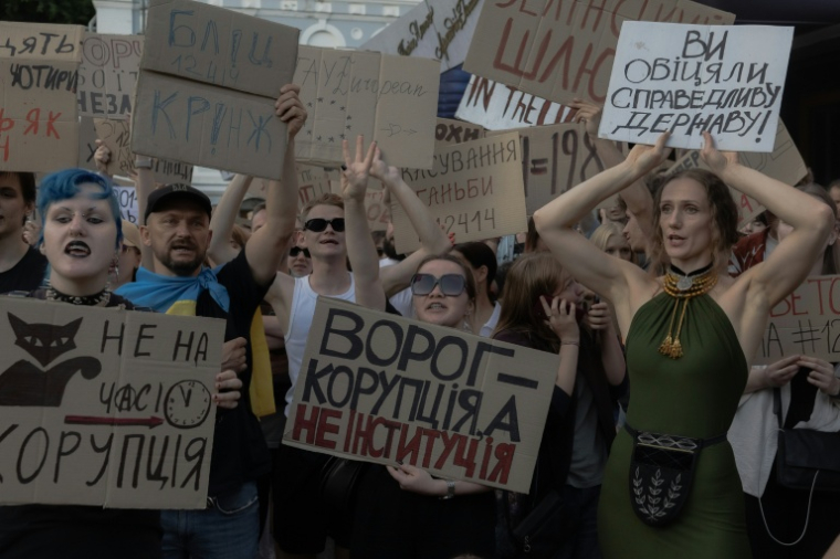 Des manifestants brandissent des pancartes lors d'une manifestation contre une loi qui supprime l'indépendance d'organismes anticorruption dans le centre-ville de Kiev, le 23 juillet 2025 ( AFP / Roman PILIPEY )