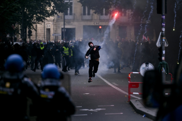 Un protestataire lance un fumigène en direction de gendarmes lors d’une manifestation contre la vie chère à Bordeaux, le 17 octobre 2026 ( AFP / Christophe ARCHAMBAULT )
