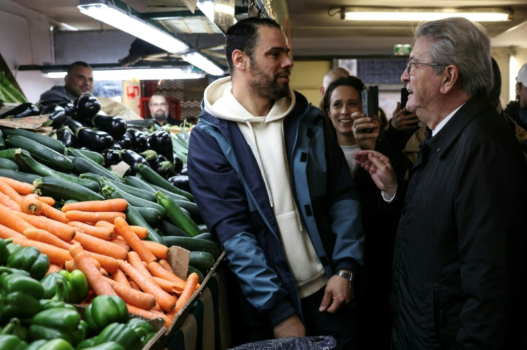 Jean-Luc Mélenchon échange avec un passant, dimanche matin au marché de Choisy-le-Roi, près de Paris ( AFP / Thomas SAMSON )