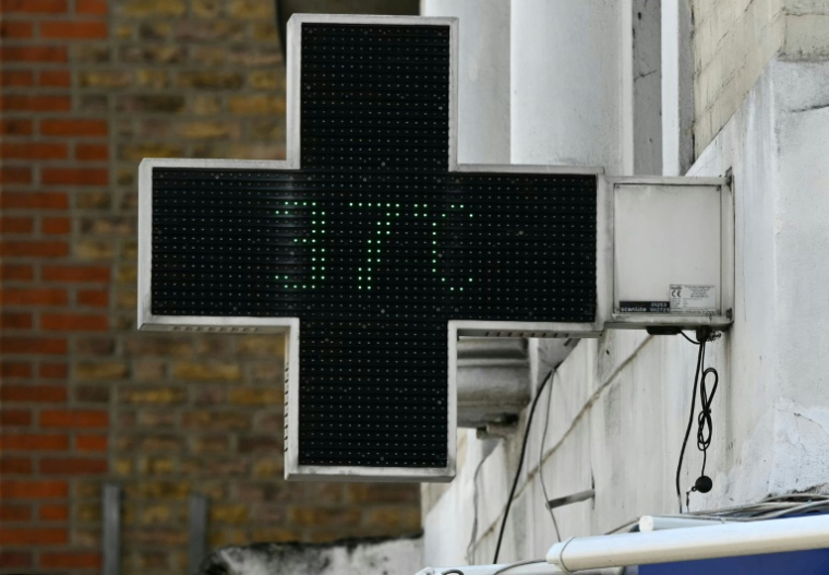 Une croix lumineuse de pharmacie affiche une température de 37°C le 24 juin 2026 à Londres ( AFP / JUSTIN TALLIS )