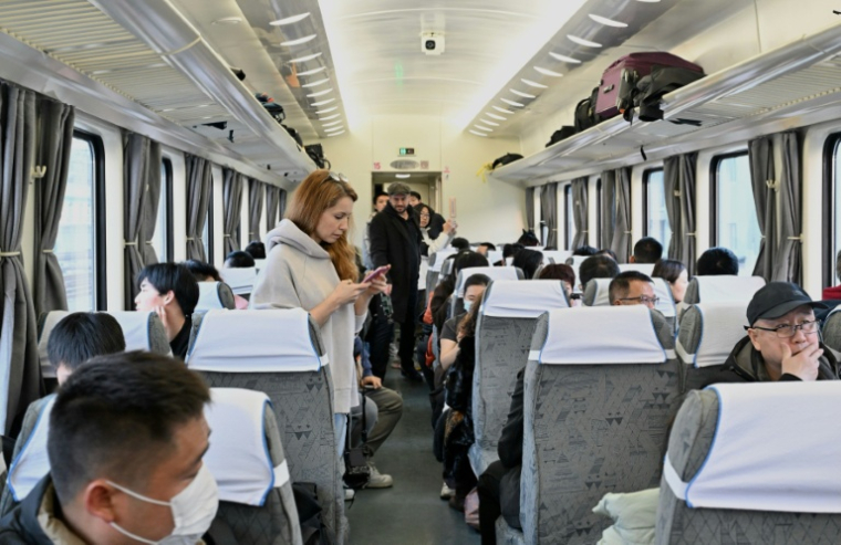 Des passagers à bord du train K27 à destination de Pyongyang à la gare de Pékin, le 12 mars 2026 en Chine ( AFP / ADEK BERRY )