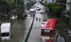 Des passants marchent le long d’une route inondée de Petchaburi à Bangkok, le 26 septembre 2026 ( AFP / Lillian SUWANRUMPHA )
