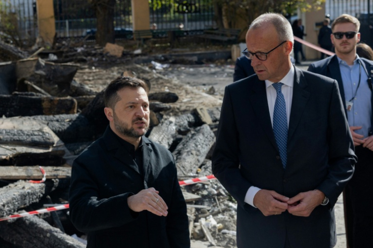 Le président ukrainien Volodymyr Zelensky (G) et le chancelier allemand Friedrich Merz (D) lors d'une visite du bâtiment endommagé de l'Académie des sciences de Kiev, le 4 octobre 2026  ( AFP / Tetiana DZHAFAROVA )
