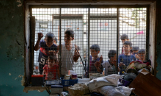 Des enfants palestiniens regardent depuis le grillage d'une salle de classe endommagée de l'école al-Farabi transformée en abri pour déplacés, après avoir été touchée par une frappe israélienne dans la ville de Gaza, le 7 septembre 2025 ( AFP / Omar AL-QATTAA )