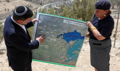 Le ministre israélien des Finances Bezalel Smotrich et une femme tiennent une carte qui montre le projet de colonisation E1