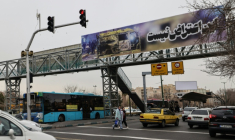 Scène de rue à Téhéran, où une bannière montrant une voiture brûlée proclame "Ceci n'est pas une protestation", le 15 janvier 2026 ( AFP / ATTA KENARE )