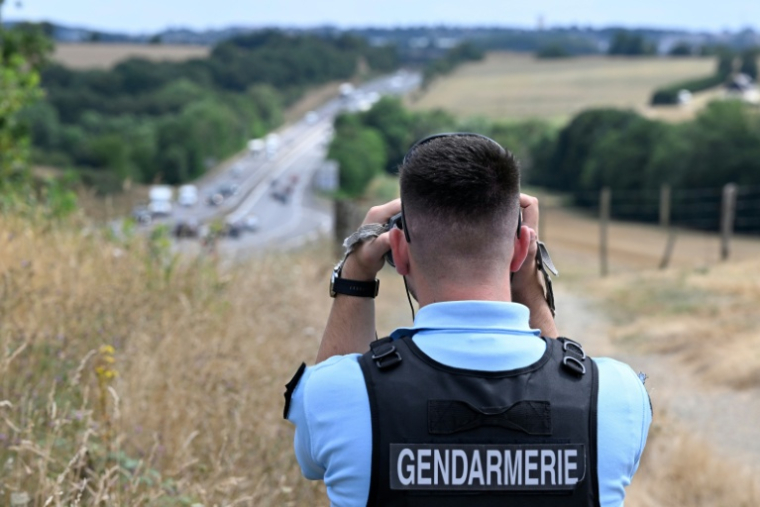 Un gendarme contrôle la vitesse des véhicules sur une route nationale à l'aide d'un radar jumelle, le 29 juillet 2022 à Poligné, en Ille-et-Vilaine ( AFP / Damien MEYER )