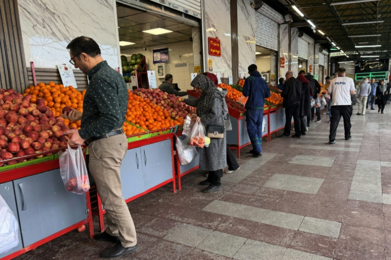 Des Iraniens font leurs courses de fruits et légumes sur un marché du nord de Téhéran, le 21 avril 2026 ( AFP / ATTA KENARE )