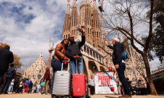 Des touristes prennent un selfie à côté de la basilique de la Sagrada Familia à Barcelone
