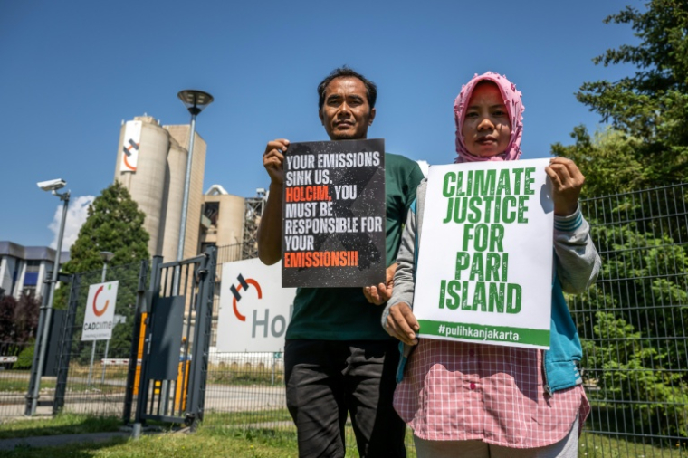 Des habitants de l'île de Pari, en Indonésie, devant une usine du cimentier suisse Holcim à Éclépens, dans l'ouest de la Suisse, le 11 juin 2026 ( AFP / Fabrice COFFRINI )